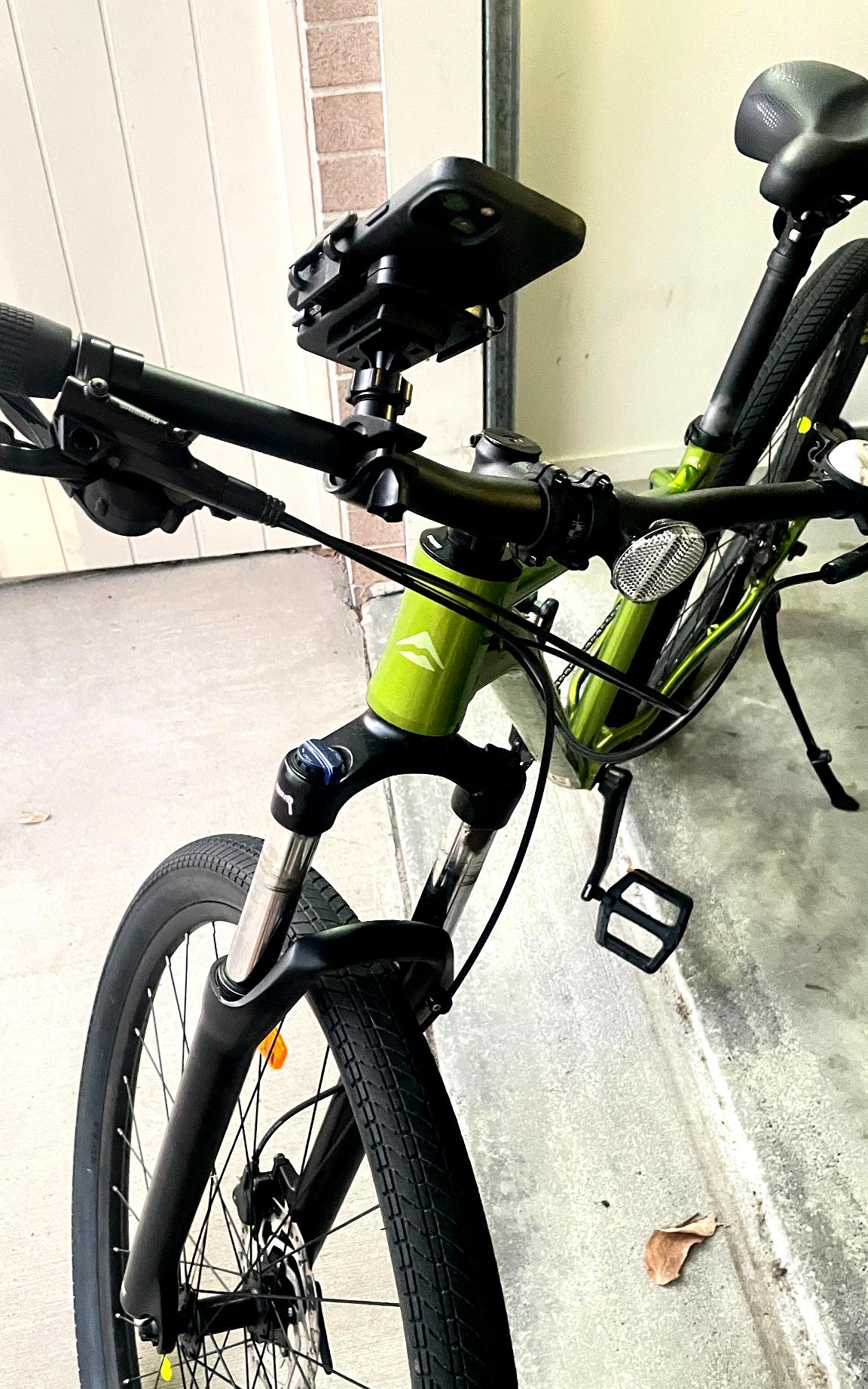 Green bicycle leaning against a wall indoors